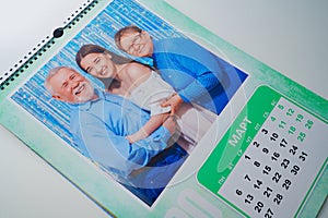 a flip calendar with family photos. grandparents with teenage granddaughters