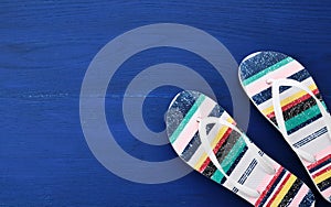 Flip flop in flat style on blue wooden background. Female fashion set
