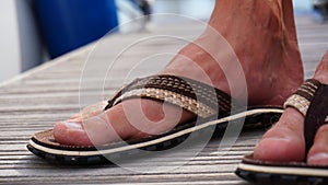 Flip flop with man foot. Summer shoes with bare feet. Flip flops for warm days and holiday walks in the outdoors.