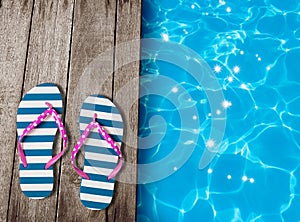 Flip flop sandals on old wooden boards near swimming pool photo