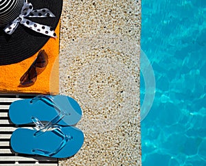 Flip Flop, towel, hat on pool edge with surface