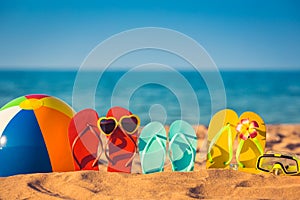 Flip-flops, beach ball and snorkel on the sand photo