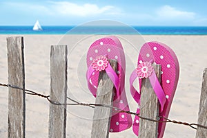 Flip flops on beach fence