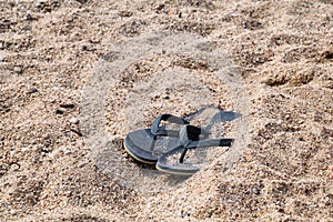 Flip flops on beach sand / Slippers on sandy beach vacation time, summer holiday background.