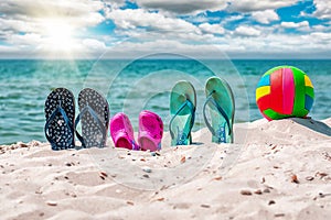 Flip-flops, beach voleyball ball on the sand. Beach summer holiday concept