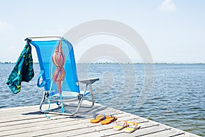 Flip-flops, bikini and swimming trunks on a pier