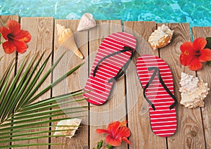 Flip flops and hibiscus flowers on wooden background. Summer holiday vacation concept. View from above