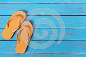 Flip flops on old weathered blue beach wood summer background