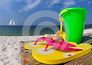 Flip flops and pail on boardwalk