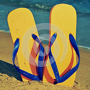 Flip-flops on the sand of a beach photo