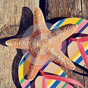 Flip-flops and starfish on a wooden pier photo