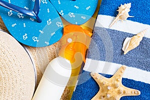 Flip flops, straw hat, starfish, sunscreen bottle, body lotion spray on yellow background top view . flat lay summer beach sea