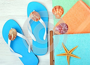 Flip-flops, towel, starfish and seashells.