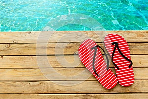 Flip flops on wooden deck over water background