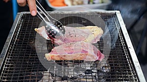 Flip the roast beef on the iron rack over the charcoal grill.