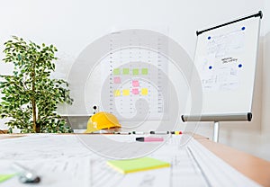 Flipchart And Yellow Hardhat At Workplace