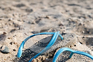Flipflop sandals lost on the beach in a sunset sun, good bye summer concept with copy space