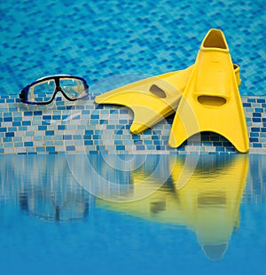 Flippers and diving mask reflected in water