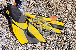 Flippers and snorkeling tube on sea shore