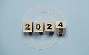 Flipping of 2023 to 2024 on wooden block cube for preparation new year change and start new business target strategy concept