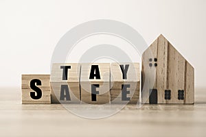 Flipping wooden blocks change wording stay and safe with wooden home. Stay home to prevent COVID 19 out break