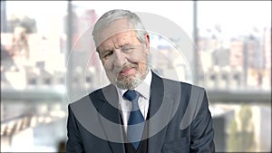 Flirtatious aged businessman, blurred background.