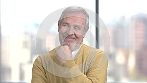 Flirtatious aged man, blurred background.