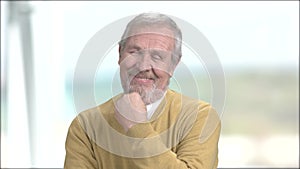 Flirtatious elderly man, blurred background.
