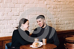 Flirting in a cafe. Beautiful loving couple sitting in cafe