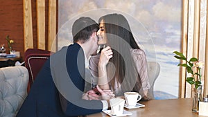 Flirting in a cafe. Beautiful loving couple sitting in a cafe enjoying in coffee and conversation