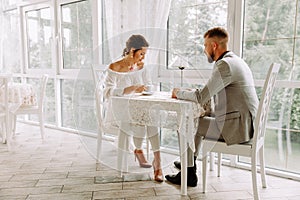 Flirting in a cafe. Beautiful loving couple sitting in a cafe enjoying in coffee and conversation