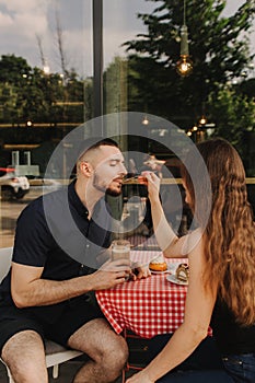 Flirting in a cafe. Beautiful loving couple sitting in a cafe enjoying in coffee and conversation. Love and romance. Blurred and