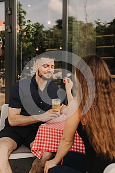 Flirting in a cafe. Beautiful loving couple sitting in a cafe enjoying in coffee and conversation. Love and romance. Blurred and