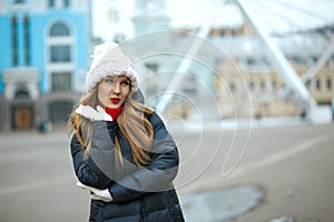 Flirty blonde model with red lipstick wearing knitted cap, enjoy
