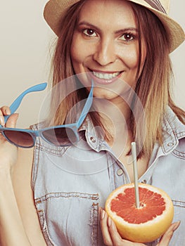 Flirty woman in hat hold sunglasses and grapefruit