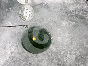 A float sits in a an ice fishing hole.