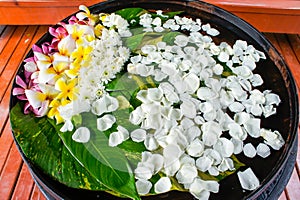 Floating assorted flowers in a big water jar.