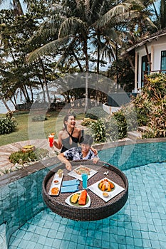 Floating breakfast in infinity pool on paradise swimming pool, morning in the tropical resort bungalow
