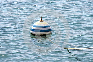 Floating buoy on a rope in sea water