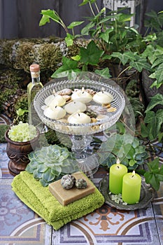 Floating candles in crystal bowl and spa cosmetics around