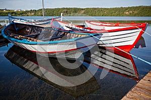 Floating Color Wooden Boats with Paddles in a Lake