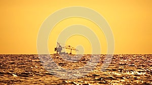 Floating Crane Vessel On Sea. Tugboat tows large crane vessel on sea horizon at sunset. Maintenance service working in