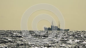 Floating Crane Vessel On Sea. Tugboat tows large crane vessel on sea horizon at sunset. Maintenance service working in