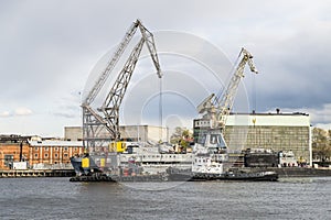 Floating cranes and tugs on the river Neva in Saint Petersburg