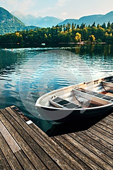 Floating dinghy moored to a wooden pier at Lake Bohinj in Slovenia