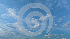 Floating fluffy clouds. Two layers of cloudiness. Blue summer sky with clouds moving in different directions. Time lapse