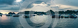 Floating Home boat in Cat Ba Island. Fisherman house boat moored in the bay in front of the city at sunset.