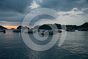 Floating Home boat in Cat Ba Island. Fisherman house boat moored in the bay in front of the city at sunset.