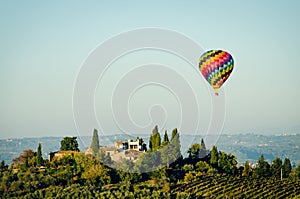 Floating hot air balloon over a Tuscan villa