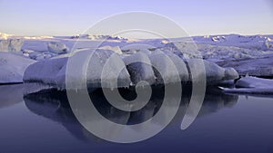 Floating ice on Jokulsarlon glacier lake in ultraviolet at sunrise